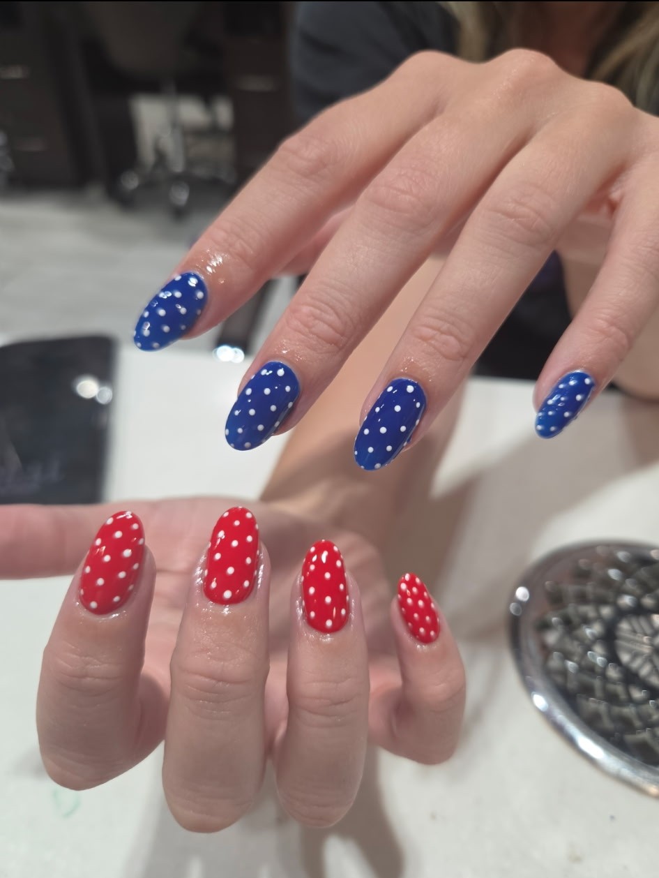 Red and navy nails covered in evenly spaced white dots